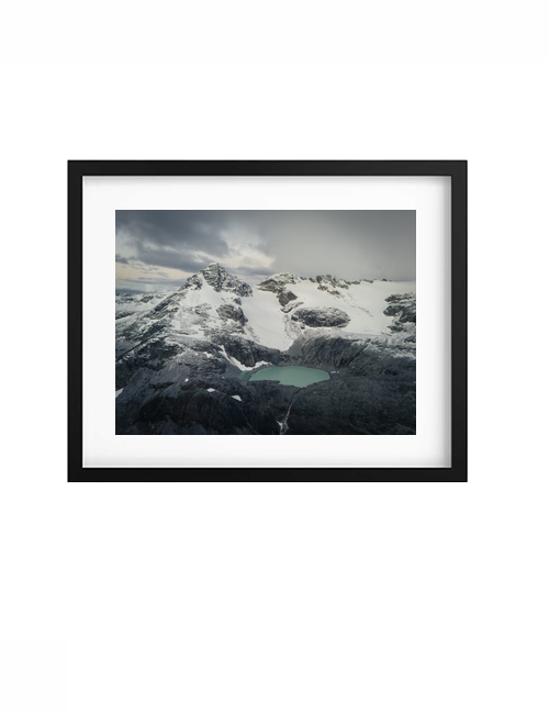 Black-framed Basin print with a white mat, showing snow-covered mountains and a turquoise lake.
