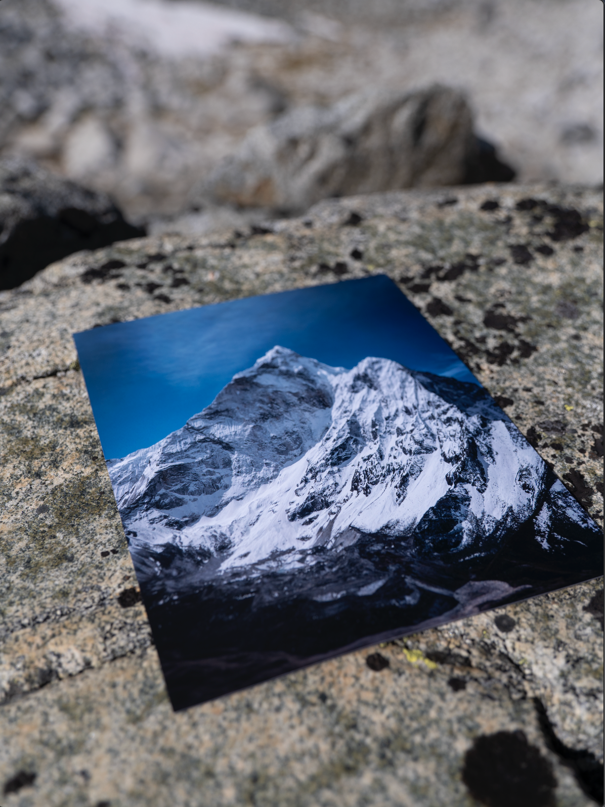 Unframed Solitude print laid on a rock outdoors.